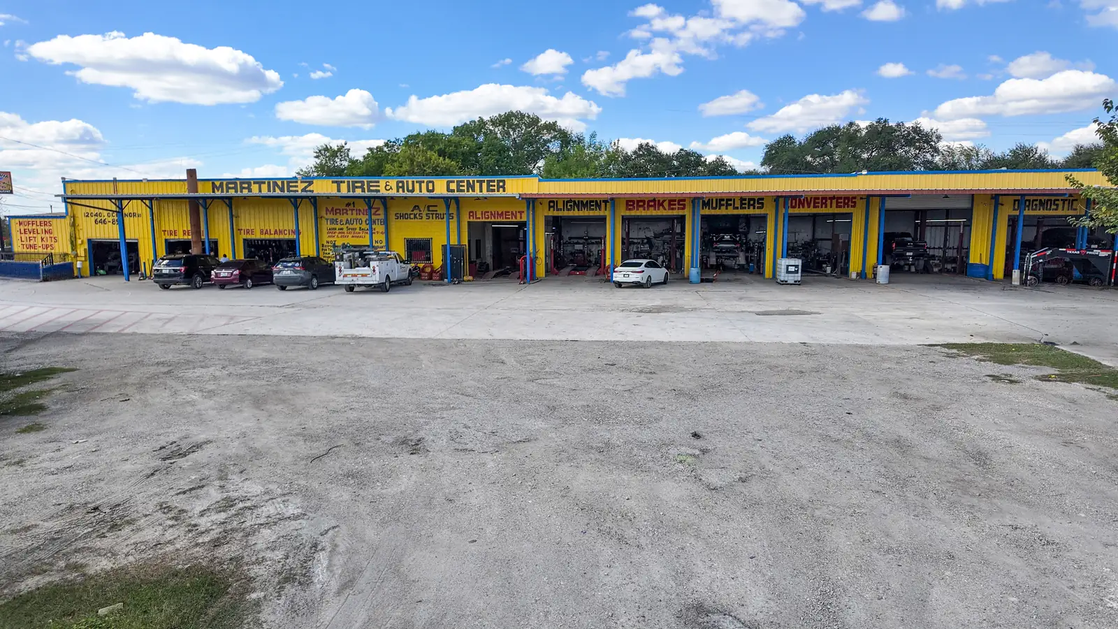 Martinez Tire & Auto Center on O'Connor Rd in San Antonio, with open bays for alignment, brakes, mufflers, and converters